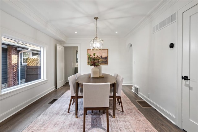 dining area with visible vents, dark wood finished floors, arched walkways, an inviting chandelier, and baseboards