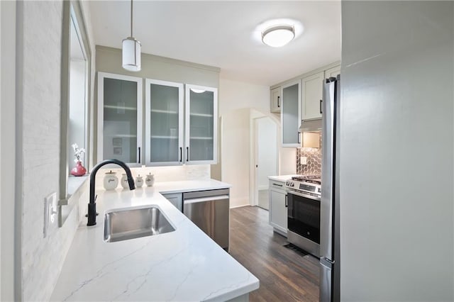 kitchen featuring dark wood-style flooring, a sink, glass insert cabinets, appliances with stainless steel finishes, and tasteful backsplash