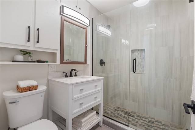 full bath featuring a stall shower, toilet, and vanity