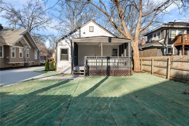 back of house featuring a yard, a deck, and fence