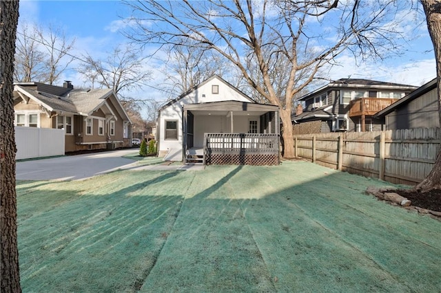 back of house with a yard, a deck, and fence