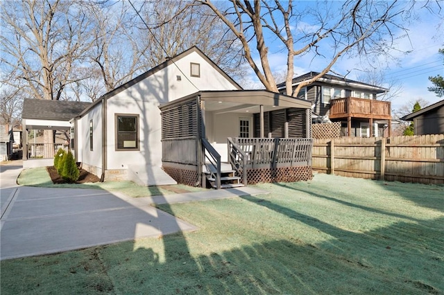 back of property featuring a deck, a yard, fence, and crawl space