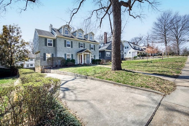 view of front of home featuring a front lawn and a chimney