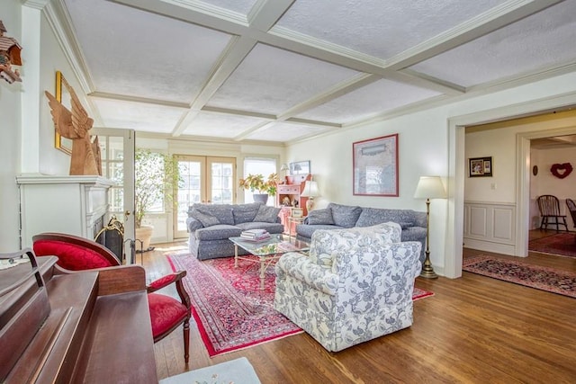 living room featuring crown molding, wood finished floors, coffered ceiling, and a textured ceiling