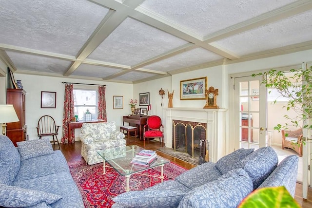 living area featuring coffered ceiling, a brick fireplace, wood finished floors, and a textured ceiling