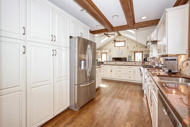 kitchen featuring a peninsula, a sink, ceiling fan, stainless steel appliances, and white cabinetry