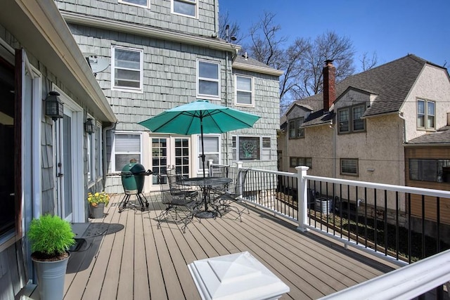 deck with outdoor dining space and grilling area