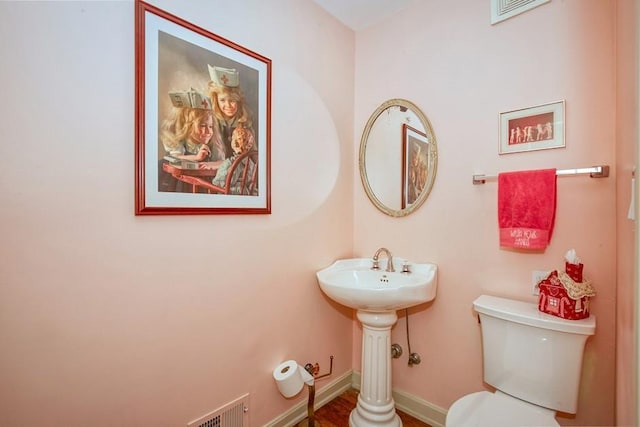 bathroom with visible vents, baseboards, and toilet