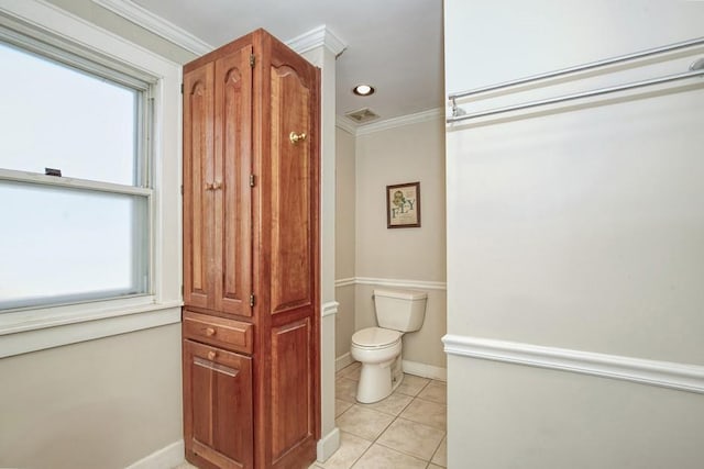 bathroom with tile patterned flooring, toilet, crown molding, and baseboards