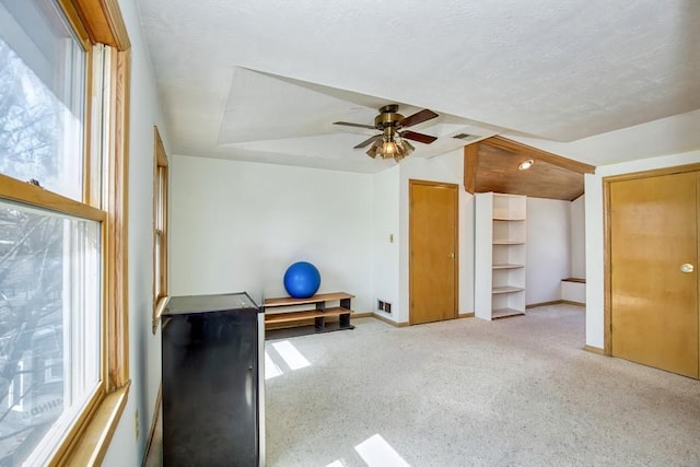 interior space with visible vents, baseboards, carpet floors, ceiling fan, and a textured ceiling