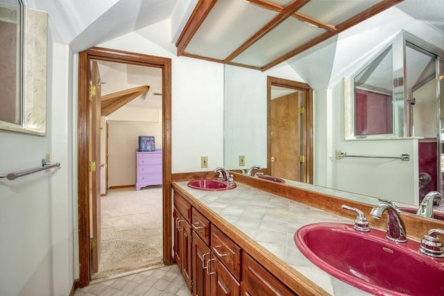 full bath featuring double vanity, lofted ceiling, and a sink