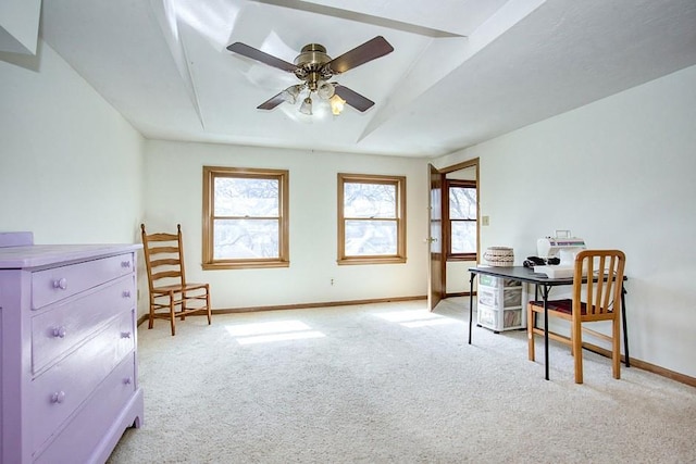 office space featuring light carpet, a ceiling fan, and baseboards