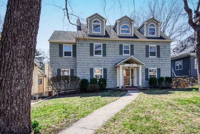 view of front of house with central AC unit and a front yard