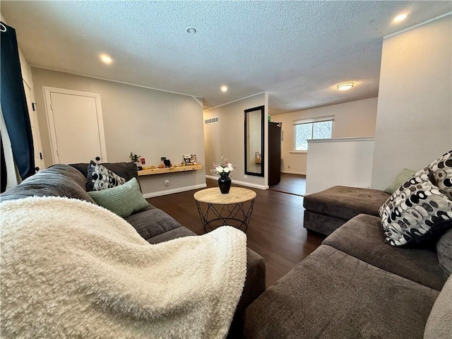 living area with visible vents, baseboards, recessed lighting, wood finished floors, and a textured ceiling