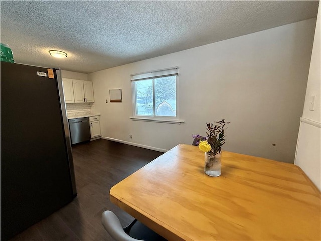 dining area featuring dark wood-type flooring, baseboards, and a textured ceiling