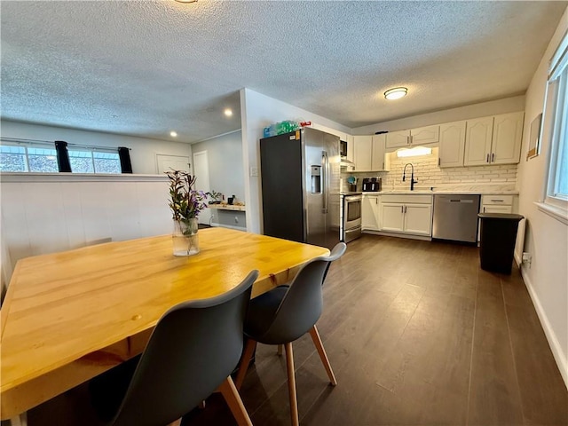 dining area featuring a textured ceiling and dark wood-type flooring