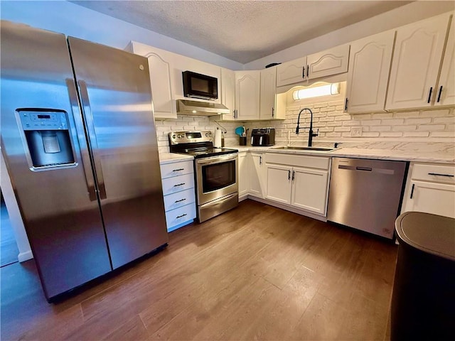 kitchen featuring a sink, appliances with stainless steel finishes, white cabinets, and dark wood-style flooring