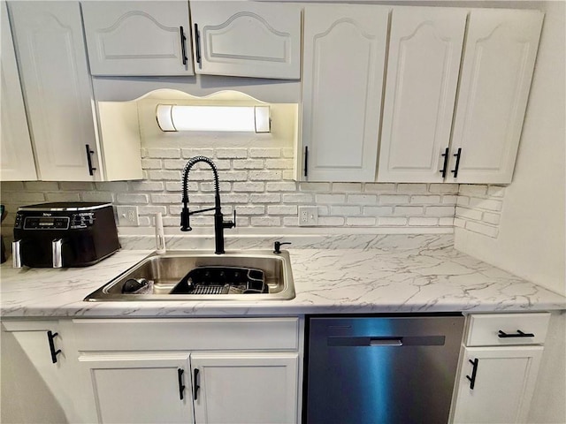 kitchen with a sink, tasteful backsplash, stainless steel dishwasher, and white cabinets