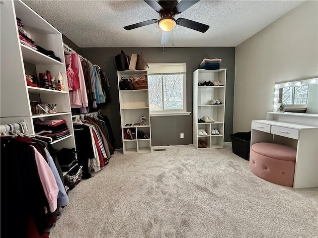 walk in closet featuring carpet flooring and a ceiling fan