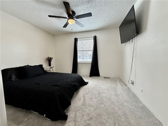 carpeted bedroom with ceiling fan, visible vents, and a textured ceiling