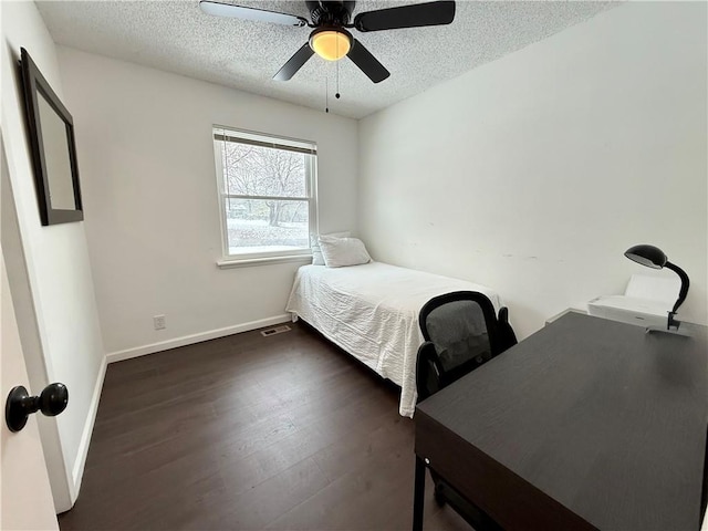 bedroom with visible vents, baseboards, a textured ceiling, and dark wood-style floors