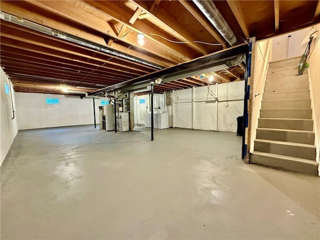 unfinished below grade area with water heater, stairway, and washing machine and dryer