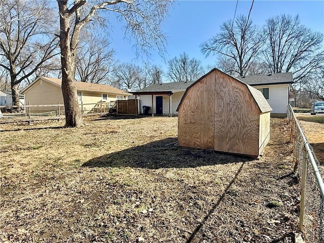 exterior space featuring a storage unit, an outbuilding, and fence