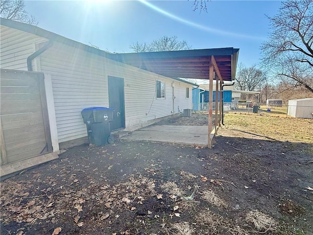 view of home's exterior with central air condition unit and a carport