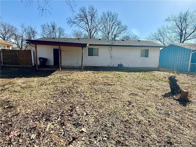 rear view of house featuring a gate and fence