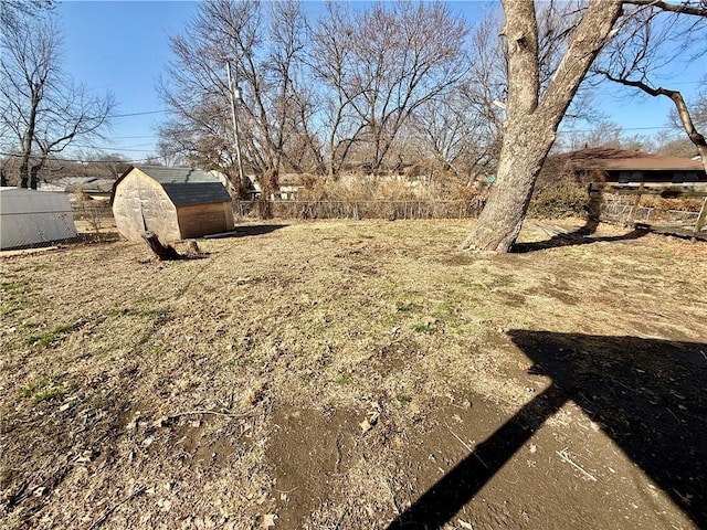 view of yard with an outbuilding, a shed, and fence