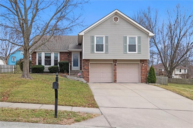 split level home with concrete driveway, brick siding, fence, and a front lawn