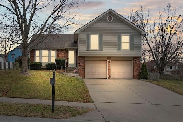 split level home with brick siding, a front lawn, and fence