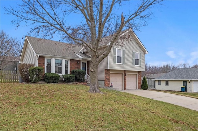 tri-level home featuring brick siding, concrete driveway, an attached garage, fence, and a front lawn