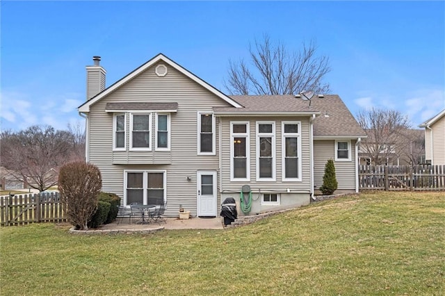 back of house with a patio, fence, a yard, roof with shingles, and a chimney