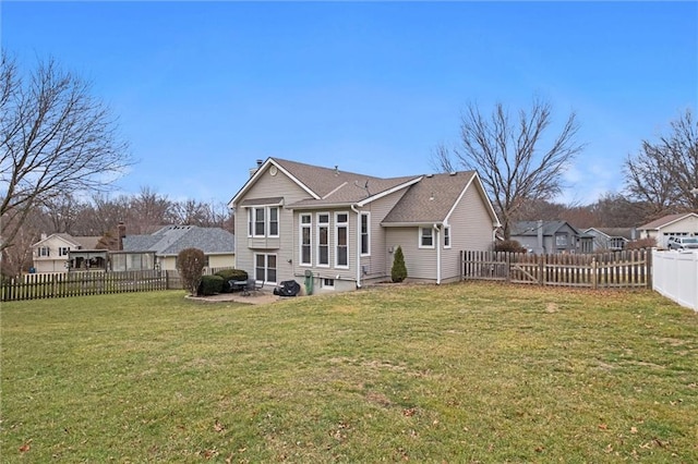 back of property featuring a residential view, a fenced backyard, a lawn, and a chimney