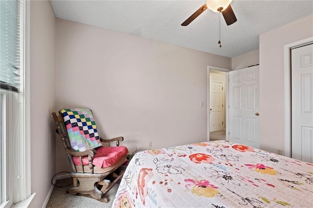 carpeted bedroom with a textured ceiling and a ceiling fan