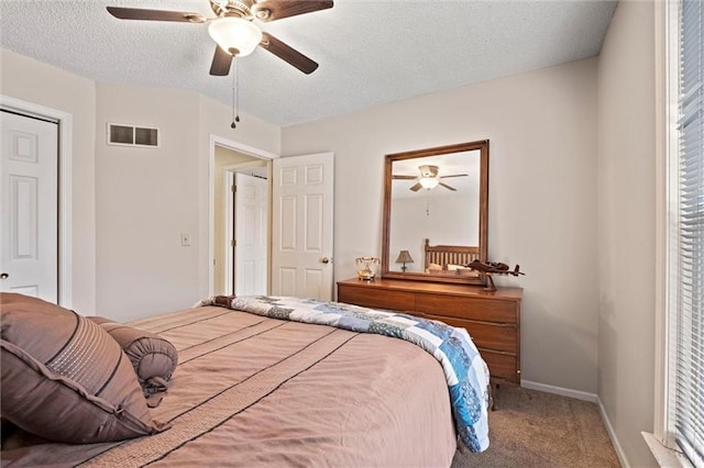 bedroom featuring visible vents, carpet flooring, ceiling fan, a textured ceiling, and baseboards