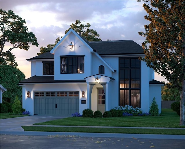 view of front of property featuring driveway, an attached garage, a front yard, and stucco siding