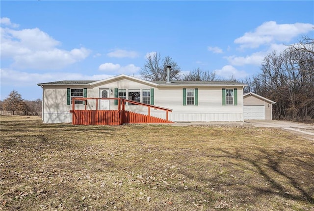 manufactured / mobile home with an outbuilding, a garage, a front lawn, and a deck