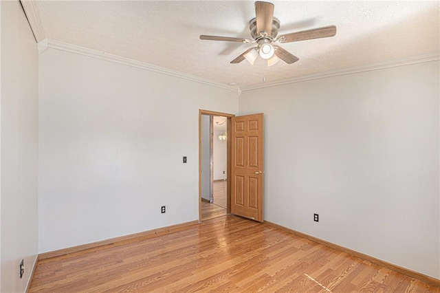 spare room with crown molding, baseboards, ceiling fan, light wood-type flooring, and a textured ceiling