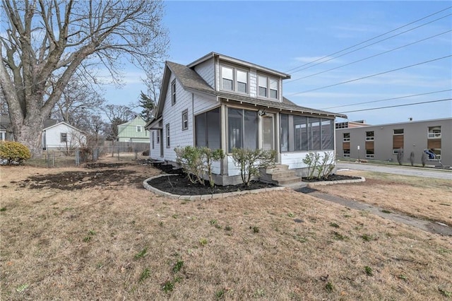 view of front of house with a sunroom and fence