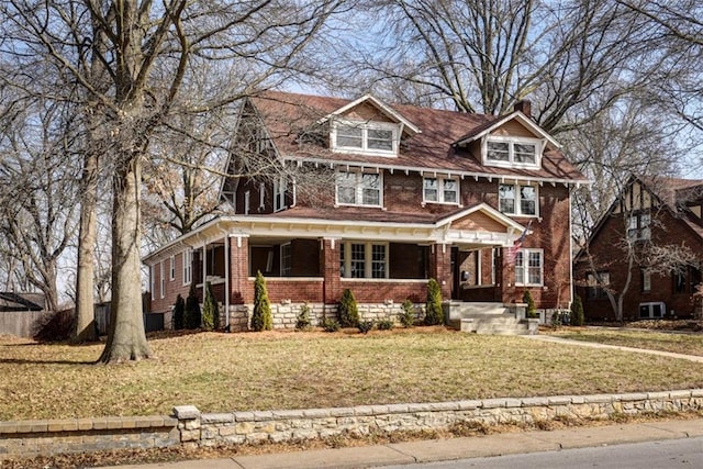 view of front of house featuring brick siding, a front lawn, and a chimney