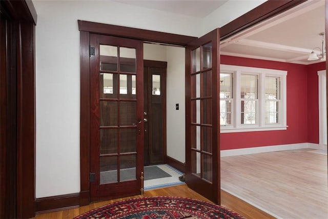 entryway featuring french doors, baseboards, and wood finished floors