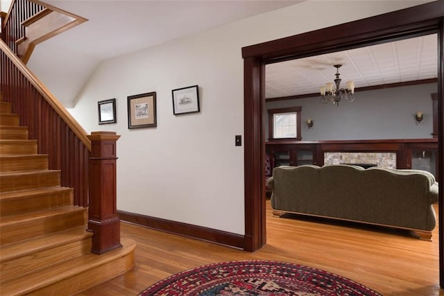 interior space with a notable chandelier, baseboards, and wood finished floors