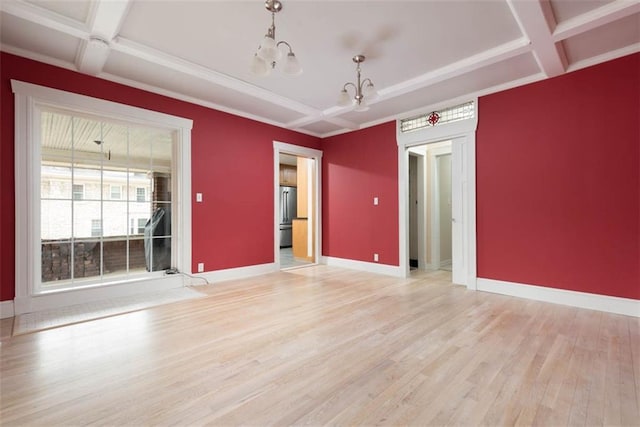 spare room featuring a chandelier, light wood-type flooring, coffered ceiling, beamed ceiling, and baseboards