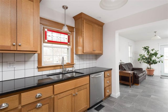 kitchen with a healthy amount of sunlight, brown cabinets, a sink, and dishwasher