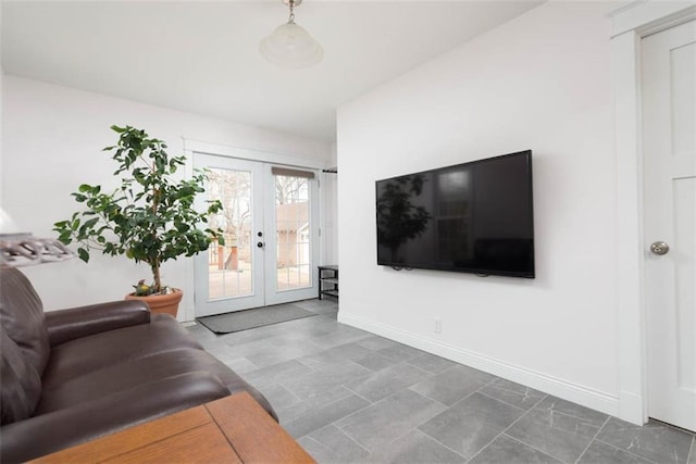 living area featuring french doors and baseboards