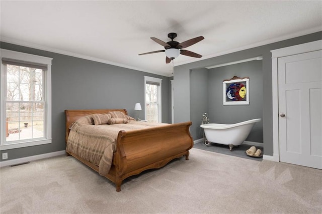 carpeted bedroom with a ceiling fan, visible vents, baseboards, and crown molding