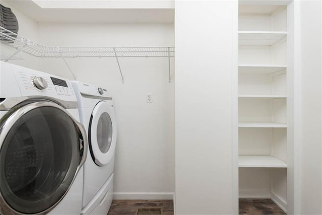 washroom with laundry area, washing machine and dryer, baseboards, and dark wood-style flooring