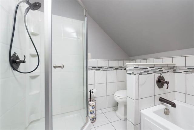 bathroom featuring toilet, tile walls, vaulted ceiling, a tub, and a stall shower